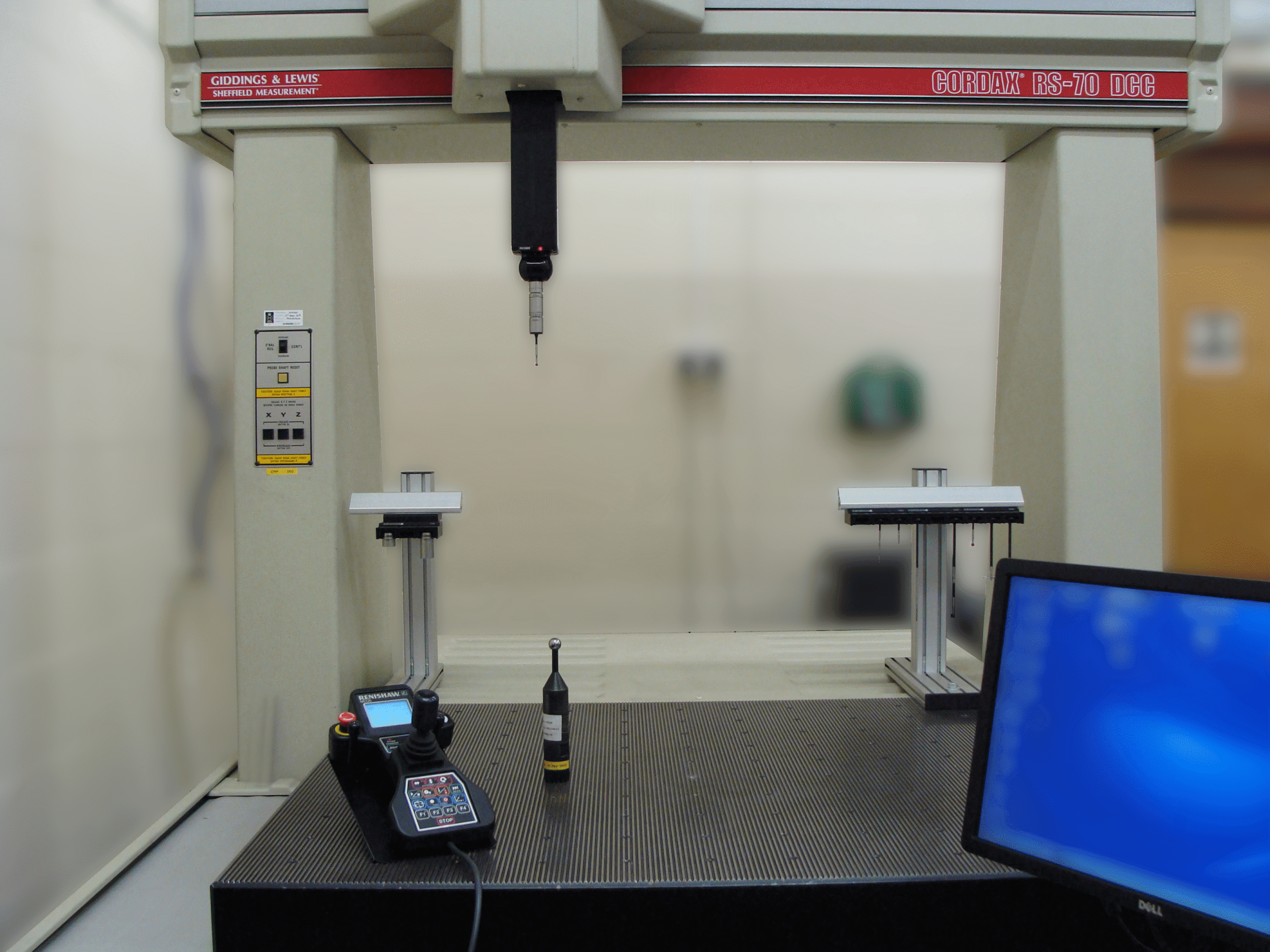 Black aluminium bead with calibration sphere on cream frame CMM with PC monitor in the corner