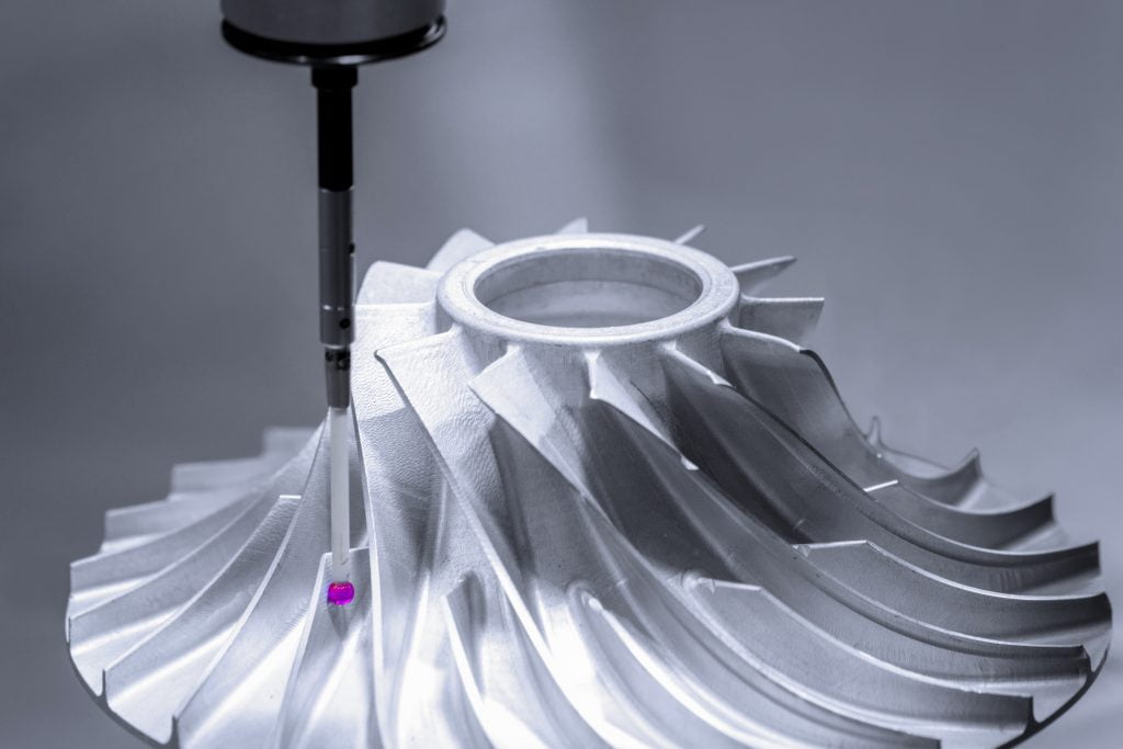 Photo showing the CMM inspection of a silver impeller using a ruby tip probe.